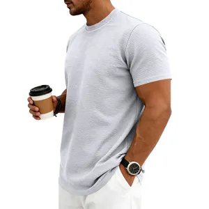 Gros plan sur le t-shirt manches courtes homme en tricot texturé de couleur gris clair.