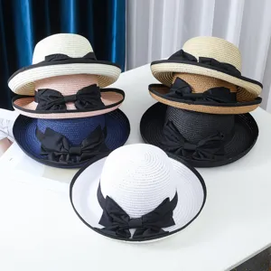 Vista detallada de sombrero de paja de playa de verano para mujer con lazo negro, protección solar.