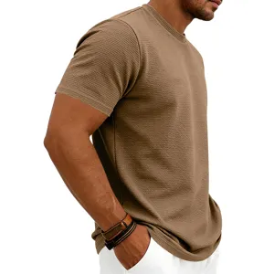 Vue détaillée du tissu et de la coupe du t-shirt marron à col rond et texture tricot.