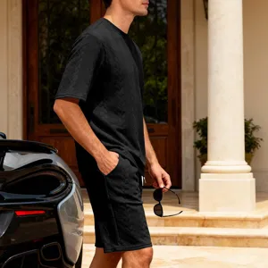 Detailed shot of men's black knit jacquard short sleeve and shorts set in luxury villa setting.