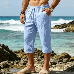Detail view of light blue men's casual cropped pants featuring drawstring and pleated.