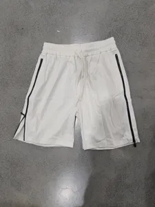 Gros plan sur les détails du short décontracté avec zips noirs latéraux et cordon réglable.