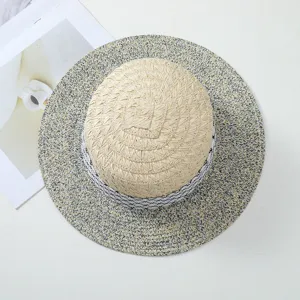 Vista di dettaglio del cappello di paglia estivo con nastro fantasia in bianco e nero.