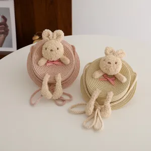 Borsa rotonda in paglia per bambini dettaglio con simpatico coniglietto di peluche.