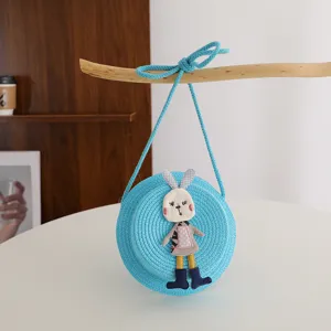 Blue woven straw crossbody bag detail featuring cute rabbit decoration for children daily use scene.