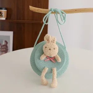 Borsa rotonda a tracolla in paglia verde per bambini con grazioso coniglio peluche dettaglio primavera.