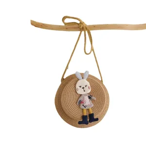 Cute kids straw crossbody bag with adorable rabbit plush applique, perfect for summer beach.