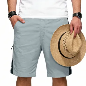 Short de sport d'été ample et décontracté pour homme avec poches zippées latérales et tissu gris.