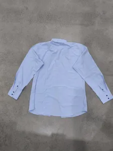 Detail view of light blue long sleeve men's dress shirt back displaying neat cuff buttons