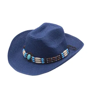 Gros plan sur le chapeau de cowboy en paille bleue avec des perles en bois et turquoise.