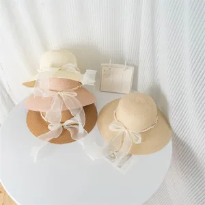 Cappello da spiaggia in paglia stile francese con perle e nastro in organza bianco.
