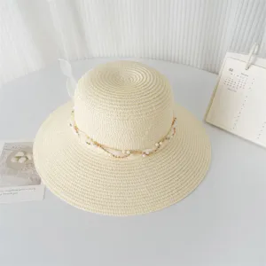 Primo piano dettagliato dell'elegante cappello di paglia beige con perle e nastro di pizzo.
