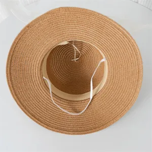 Vista dettagliata del cappello di paglia pieghevole con tesa larga e cordino per la spiaggia.