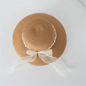 Vista dettagliata del cappello di paglia da donna con nastro trasparente e perle.