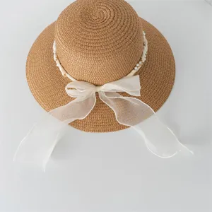 Cappello di paglia francese con nastro bianco e perle, perfetto per le vacanze al mare.