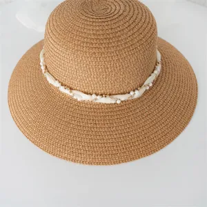Dettaglio cappello di paglia donna, tesa larga, cappello da spiaggia con perle e nastro per estate.