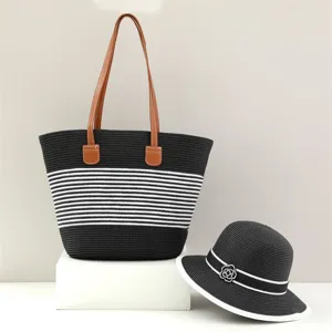 Black and white striped straw tote bag and matching sun hat set with brown handles.