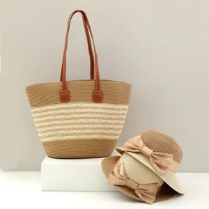 Borsa tote in paglia a righe e cappello da sole con fiocco elegante per la spiaggia.