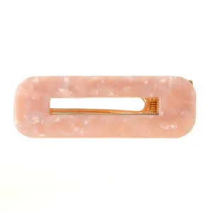 Rosa rechteckige Acetat-Haarspange mit hohlem geometrischem Design und goldenem Metallclip.
