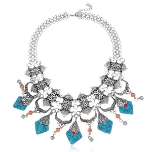 Close-up detail of vintage bohemian turquoise statement necklace, ornate silver metal design.