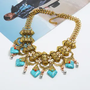 Detailed view of bohemian vintage chunky statement necklace with turquoise stones and gold chain.