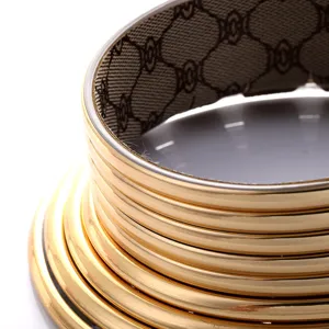Detaillierte Nahaufnahme des mehrschichtigen goldenen Halsreifens mit gemustertem Stoffinnenfutter.