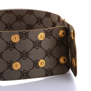 Detailansicht des breiten Mode-Choker-Halsbands mit Luxus-Monogramm-Muster und Goldknöpfen.