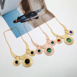 Detailaufnahme der Retro-Statement-Halskette, kunstvoll geschnitztes Metall mit bunten Edelsteinen.