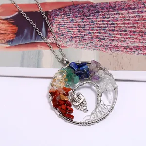 Primo piano dettagliato del ciondolo albero della vita in filo metallico con cristalli.