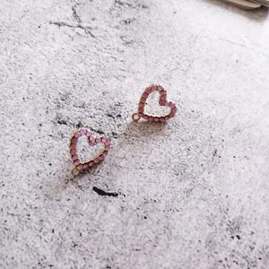 Primo piano di ciondoli a cuore in strass rosa per gioielli fai-da-te, accessori brillanti.