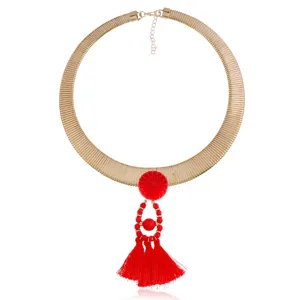 Goldene breite Schlangenkette Choker Halskette mit rotem Quasten Anhänger Detail.