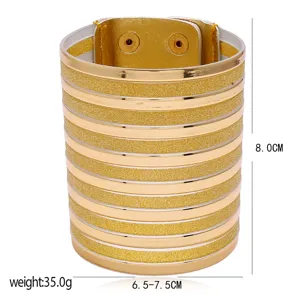 Fashion wide metallic gold cuff bracelet with glitter stripes and snap button closure.
