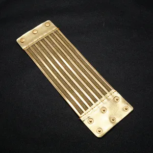 Golden wide cuff bracelet detail view, showcasing the layered metallic strips and snap button PU ends.