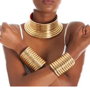 Detailed view of bold African tribal style multi-layered gold choker and wide cuff bracelets set.