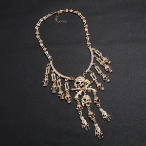 Vista detallada del collar statement gótico dorado con calavera y mano de esqueleto.