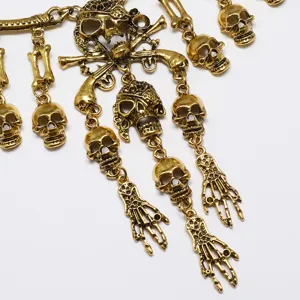 Primer plano detallado del collar de calavera dorada y mano de esqueleto con borla, estilo gótico.