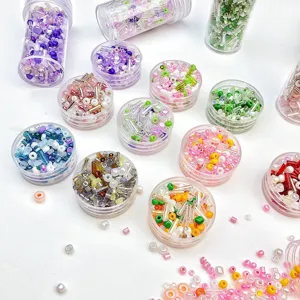 Set di perline di rocaille e tubolari colorate in barattoli trasparenti per gioielli fai da te.
