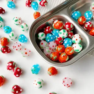 Handmade glass strawberry beads for DIY jewelry making, bracelets, necklaces, and charms.
