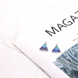 Detailed shot of the triangle alloy oil drop pendant in teal and water blue colors.