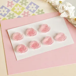 Closeup of matte pink resin rose cabochons, perfect for DIY jewelry and earrings crafting.