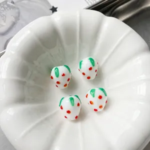 Detailed view of handmade strawberry glass beads, 12x14mm DIY jewelry making charms.
