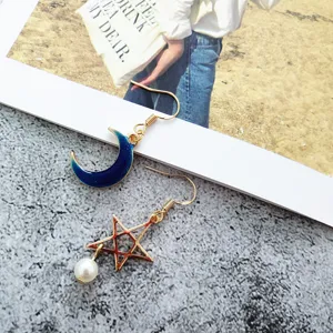 Asymmetric gold-plated moon and star earrings with pearl pendant, stylish jewelry accessory.