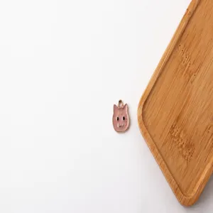 Primo piano dettagliato di un ciondolo gatto rosa in lega per accessori di gioielleria fai da te.