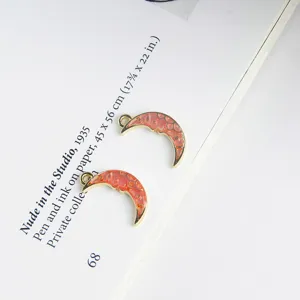 Detailopname van rode emaille halve maan legeringshangers, perfect voor DIY sieraden maken.