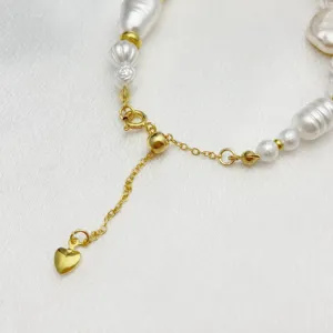 Dettaglio catena di estensione perle regolabile dorata con ciondolo a cuore e cursore in silicone.