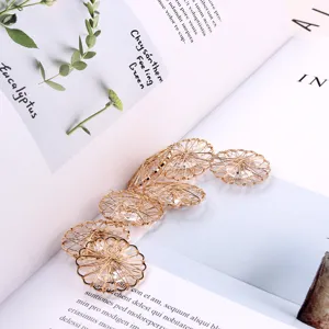Close-up detail shot of round hollow copper wire zircon DIY jewelry accessories on a book.