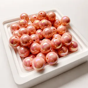 Close-up detailed view of pink iridescent resin beads for DIY jewelry and phone charms.