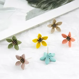 Close up of colorful spray painted flower stud earrings with metal bead pistils for DIY jewelry.