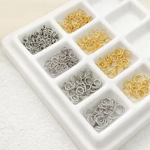 Detail shot of golden and silver metal jump rings, ideal for DIY jewelry making and connecting.