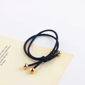Black elastic hair tie with golden balls, minimalist ponytail holder for daily wear and styling.